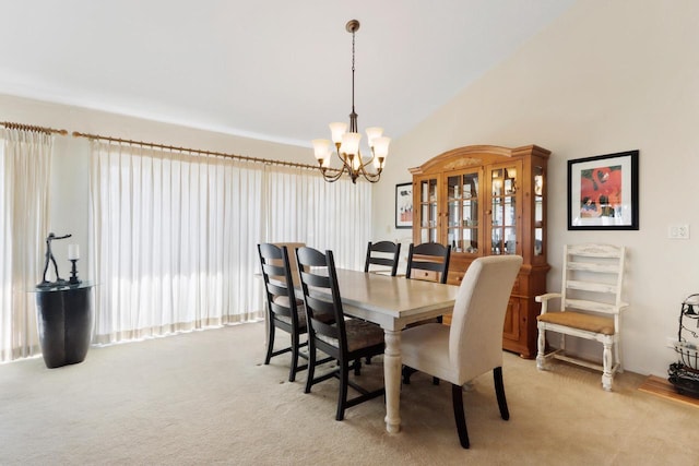 dining space featuring lofted ceiling, a notable chandelier, and light colored carpet