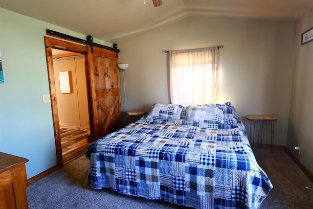 bedroom with carpet flooring, vaulted ceiling, a barn door, and baseboards