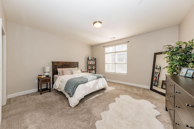 bedroom featuring baseboards and light colored carpet