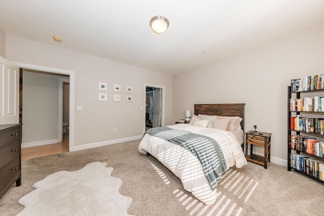 bedroom with baseboards and light carpet