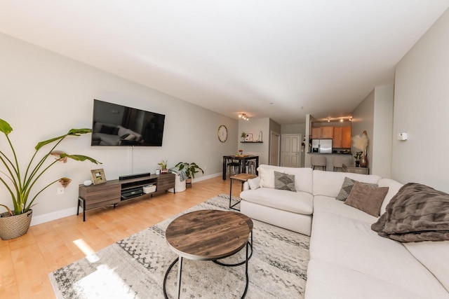 living area featuring light wood-style flooring and baseboards