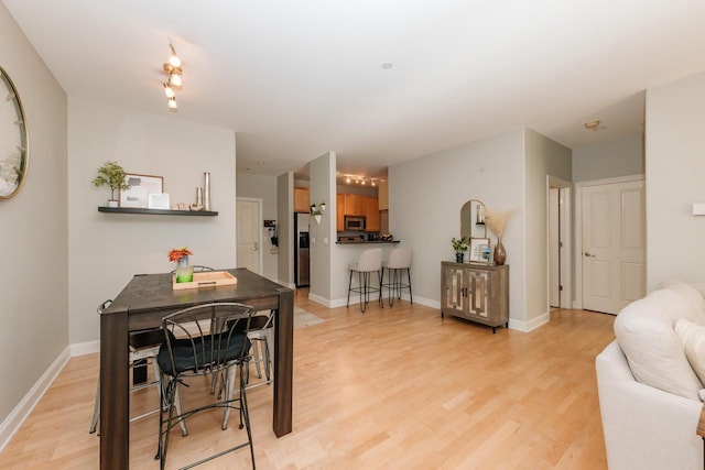 dining area with light wood-style flooring and baseboards