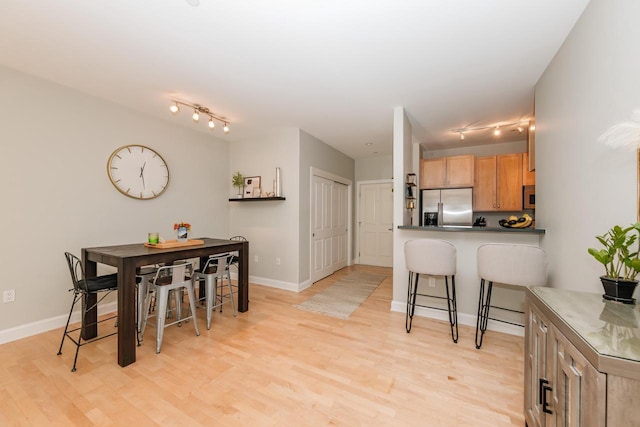 dining room with baseboards and light wood-style floors