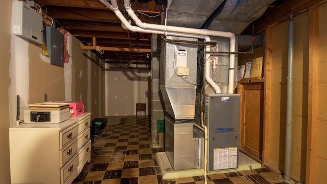 unfinished below grade area with tile patterned floors, heating unit, and electric panel