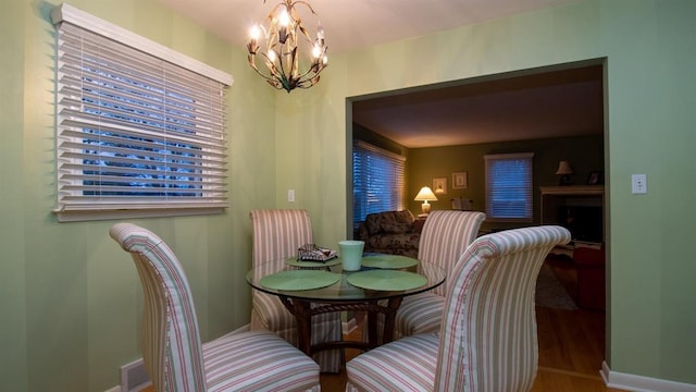 dining room with baseboards, an inviting chandelier, and wood finished floors