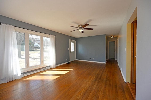 spare room with visible vents, a ceiling fan, baseboards, and wood-type flooring