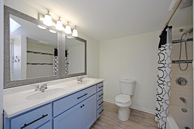 bathroom featuring a sink, wood finished floors, toilet, and shower / bath combo