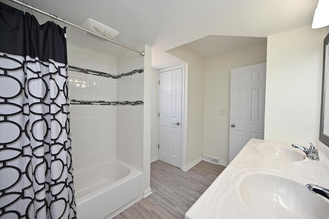 full bath featuring a sink, visible vents, wood finished floors, and shower / tub combo