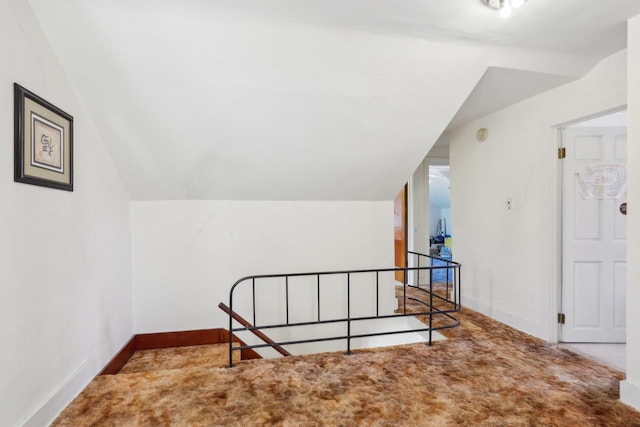 bonus room featuring vaulted ceiling, carpet flooring, and baseboards