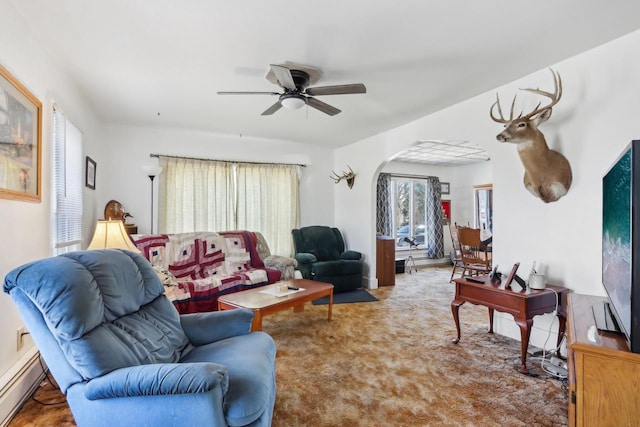 living area with arched walkways, a baseboard heating unit, ceiling fan, and carpet floors