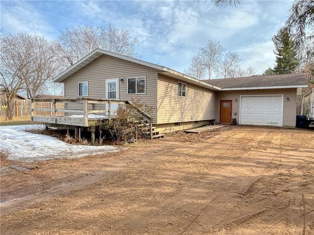 view of side of property with crawl space, a garage, a wooden deck, and dirt driveway