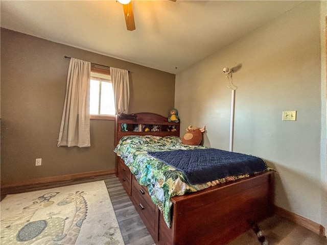 bedroom with a ceiling fan, wood finished floors, and baseboards