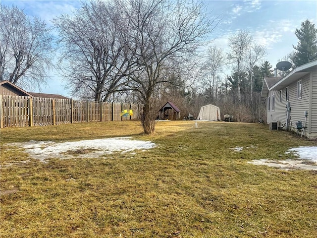 view of yard with a storage shed, fence, and an outbuilding