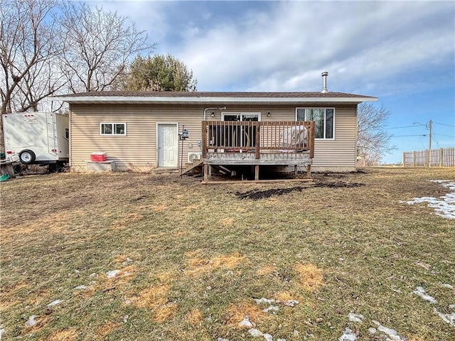 rear view of property featuring a yard and a deck