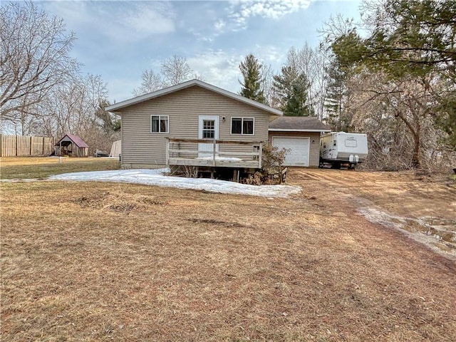 rear view of house featuring a deck, a lawn, and fence