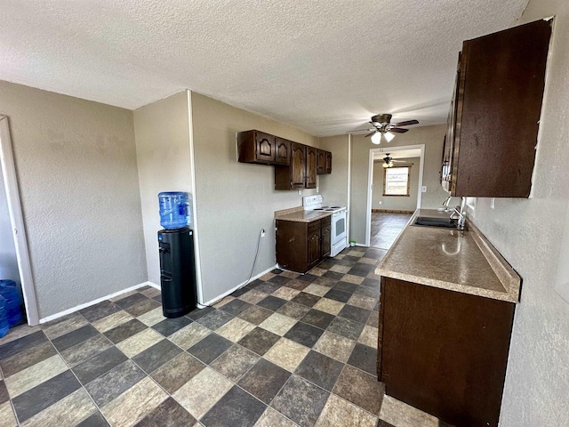 kitchen featuring baseboards, ceiling fan, dark brown cabinetry, white range with electric stovetop, and a sink