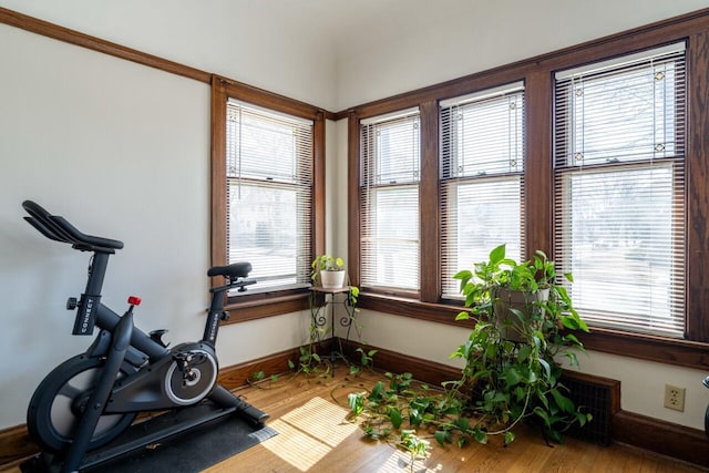 workout area with baseboards and wood finished floors