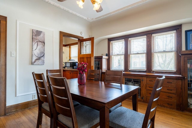 dining area featuring light wood-type flooring, baseboards, and ceiling fan