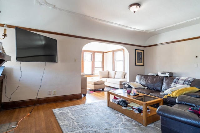 living room with lofted ceiling, wood finished floors, arched walkways, and baseboards