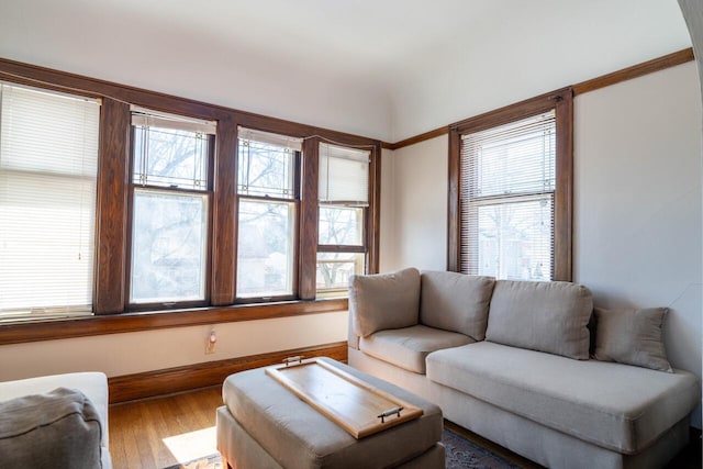 living area with baseboards and wood finished floors