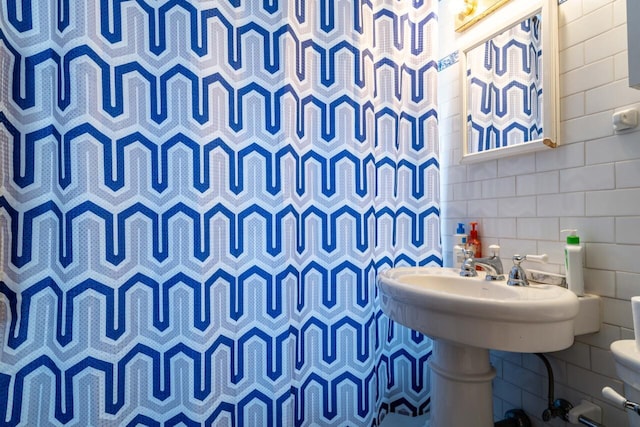 bathroom with a shower with shower curtain, tile walls, and backsplash