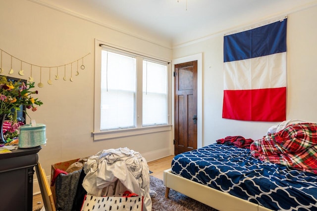 bedroom with wood finished floors and baseboards