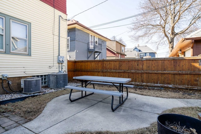 view of patio with cooling unit, outdoor dining area, and a fenced backyard