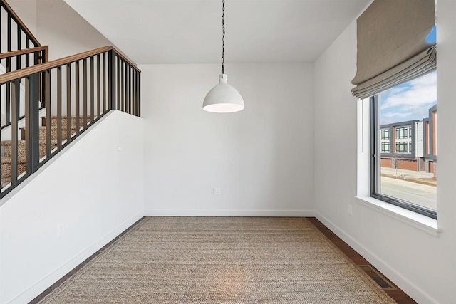 unfurnished dining area with visible vents, stairs, and baseboards