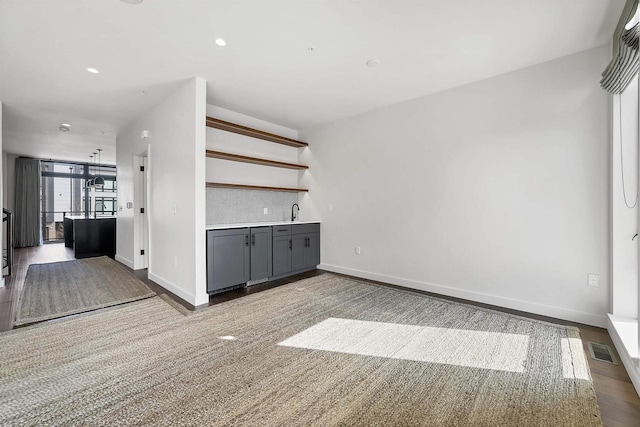 interior space featuring visible vents, recessed lighting, baseboards, and a sink