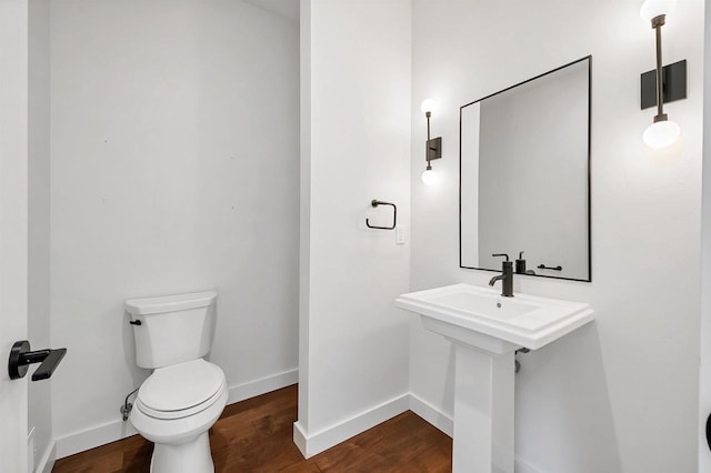 bathroom featuring baseboards, toilet, and wood finished floors