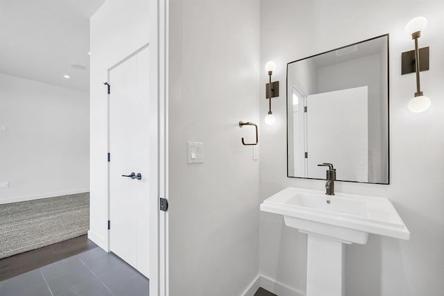 bathroom featuring baseboards and a sink