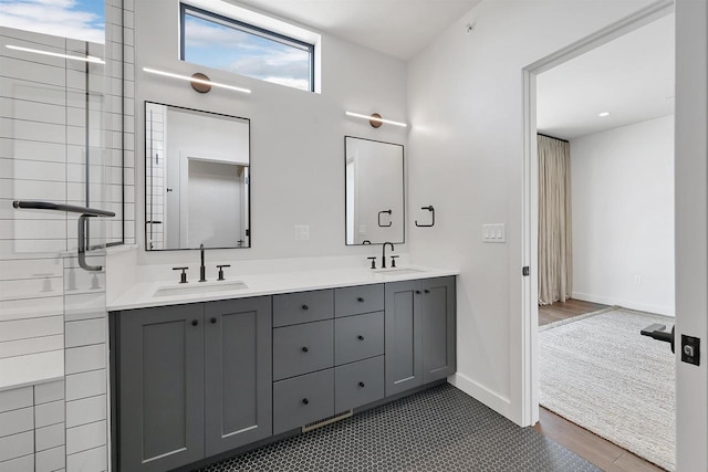 bathroom featuring a sink, baseboards, wood finished floors, and double vanity