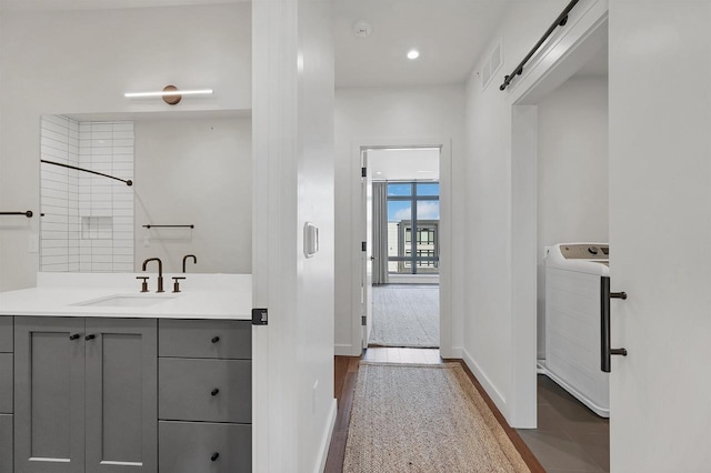 full bathroom featuring vanity, washer / clothes dryer, and baseboards