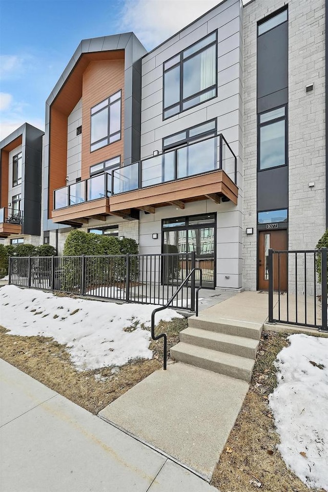 view of front of house featuring a balcony and fence