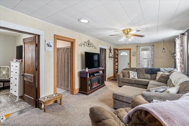 living area with baseboards, carpet floors, a fireplace, and a ceiling fan