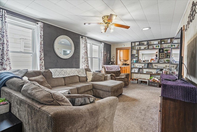 carpeted living area with a ceiling fan