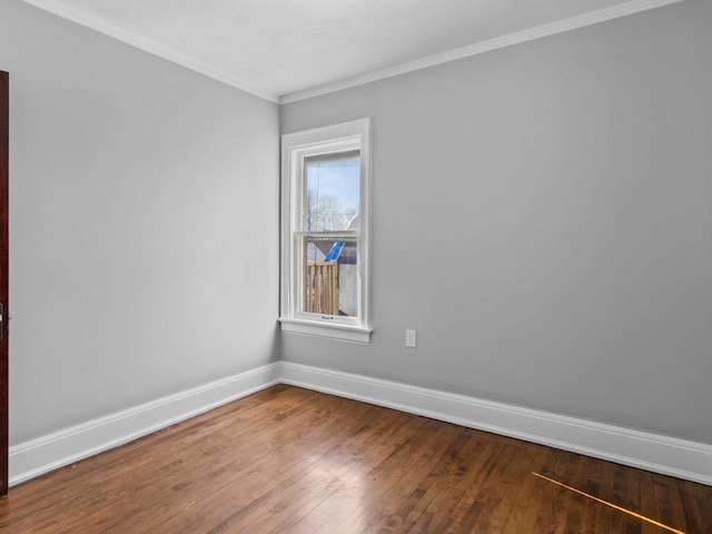 empty room with ornamental molding, baseboards, and wood-type flooring