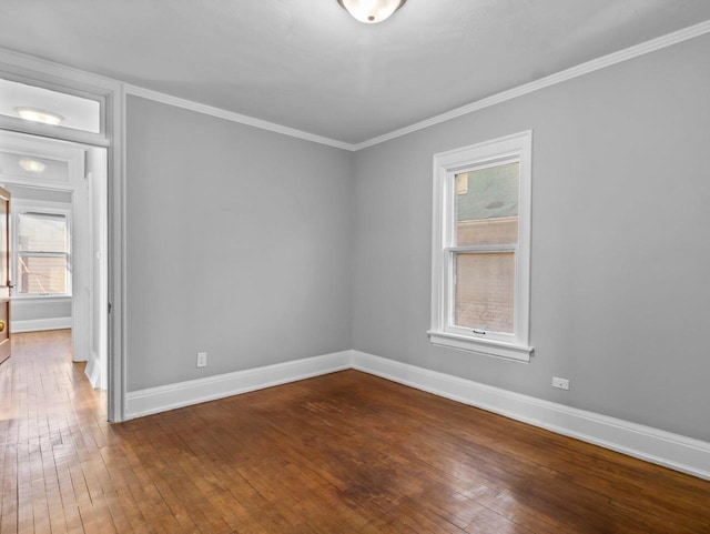 unfurnished room with dark wood-style floors, baseboards, and ornamental molding