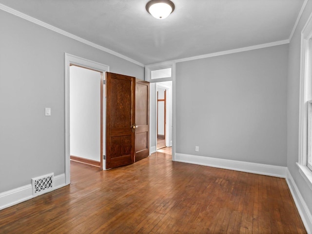 empty room with visible vents, dark wood-type flooring, and baseboards