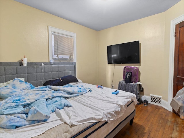 bedroom featuring visible vents, baseboards, and dark wood-type flooring