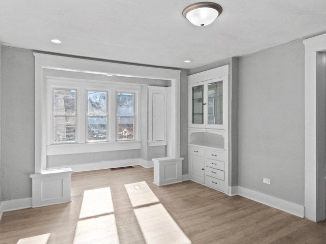 unfurnished bedroom featuring recessed lighting, light wood-style flooring, and baseboards