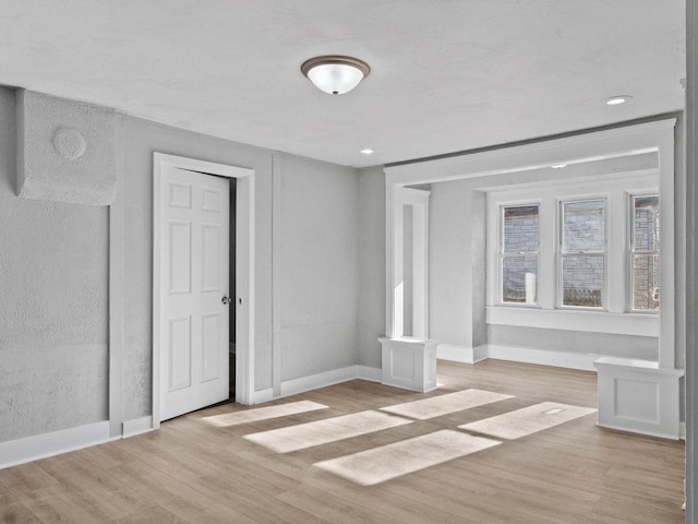 spare room with recessed lighting, baseboards, and light wood-style flooring