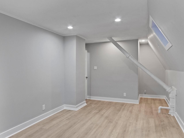 basement featuring recessed lighting, baseboards, and light wood-style floors