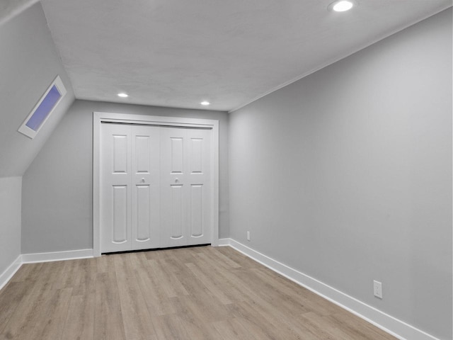 unfurnished bedroom with a closet, recessed lighting, baseboards, and wood finished floors