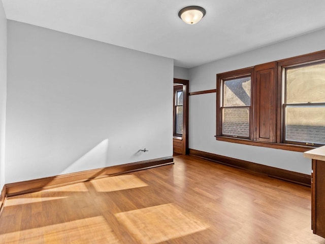 unfurnished room featuring baseboards and wood finished floors