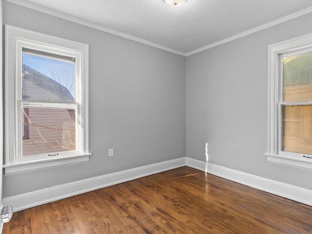 unfurnished room with crown molding, baseboards, and wood finished floors