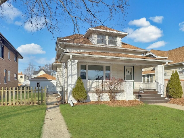 view of front of property with a front yard, a gate, fence, and covered porch