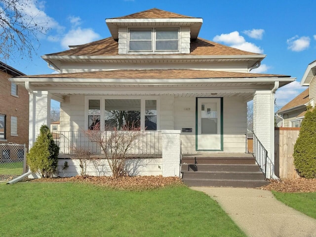 view of front of house featuring a porch, a front yard, roof with shingles, and fence