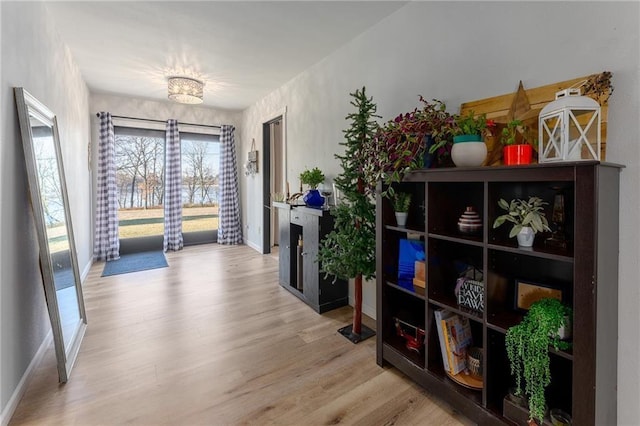 corridor featuring a notable chandelier, baseboards, and wood finished floors