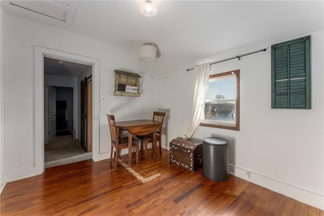 dining space with hardwood / wood-style floors and baseboards